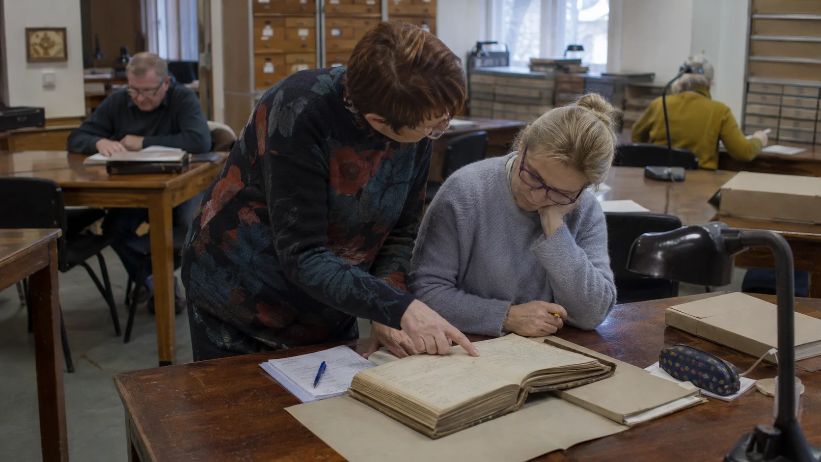 Ilustracyjne ujęcie pracy z materiałami historycznymi w czytelni archiwum